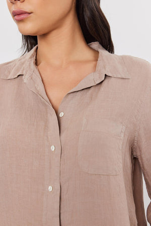 Close-up of a woman wearing a NATALIA LINEN BUTTON-UP SHIRT by Velvet by Graham & Spencer with a relaxed silhouette, collar, and front pocket.