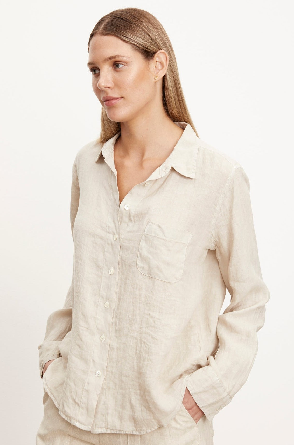   a woman wearing the NATALIA LINEN BUTTON-UP SHIRT by Velvet by Graham & Spencer in beige, along with matching pants. 