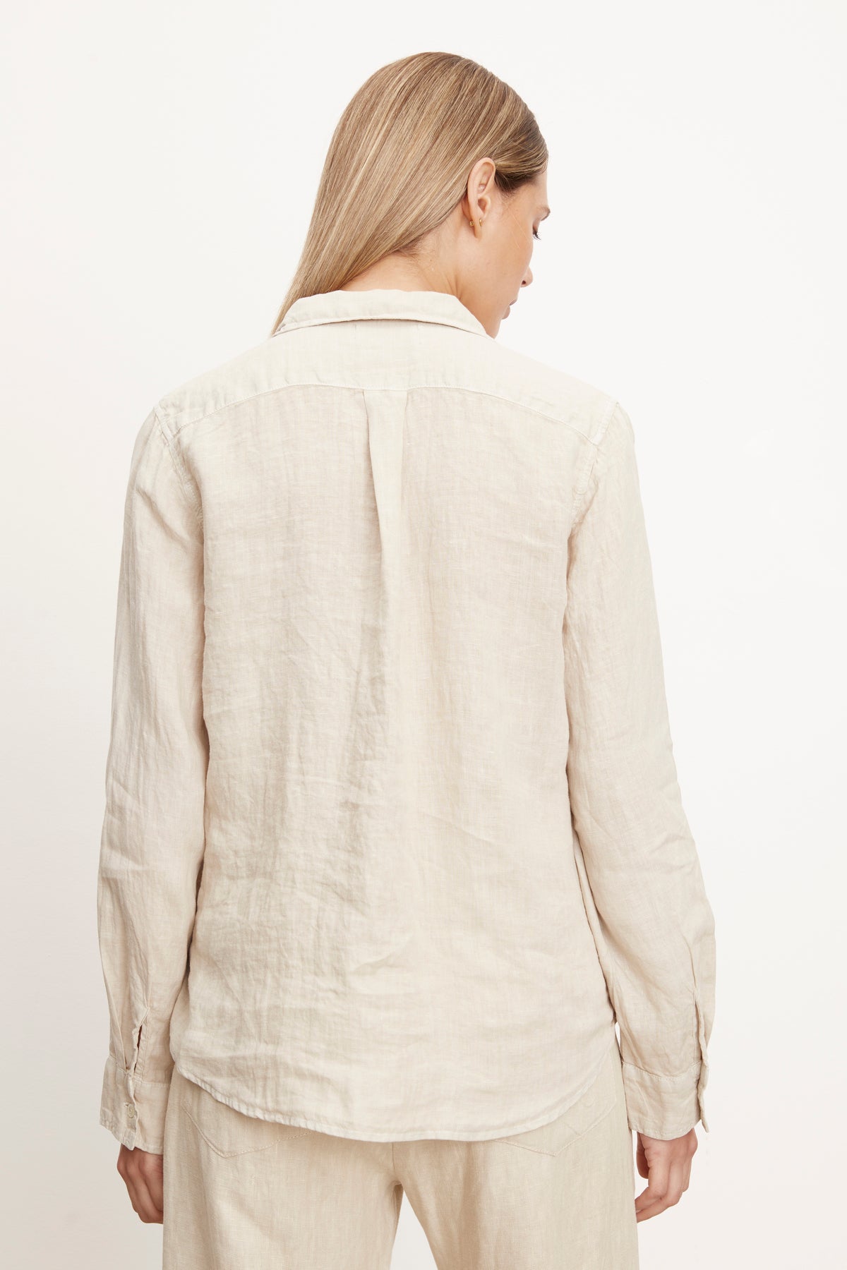 The back view of a woman wearing a Velvet by Graham & Spencer Natalia Linen Button-Up Shirt.-26423872487617