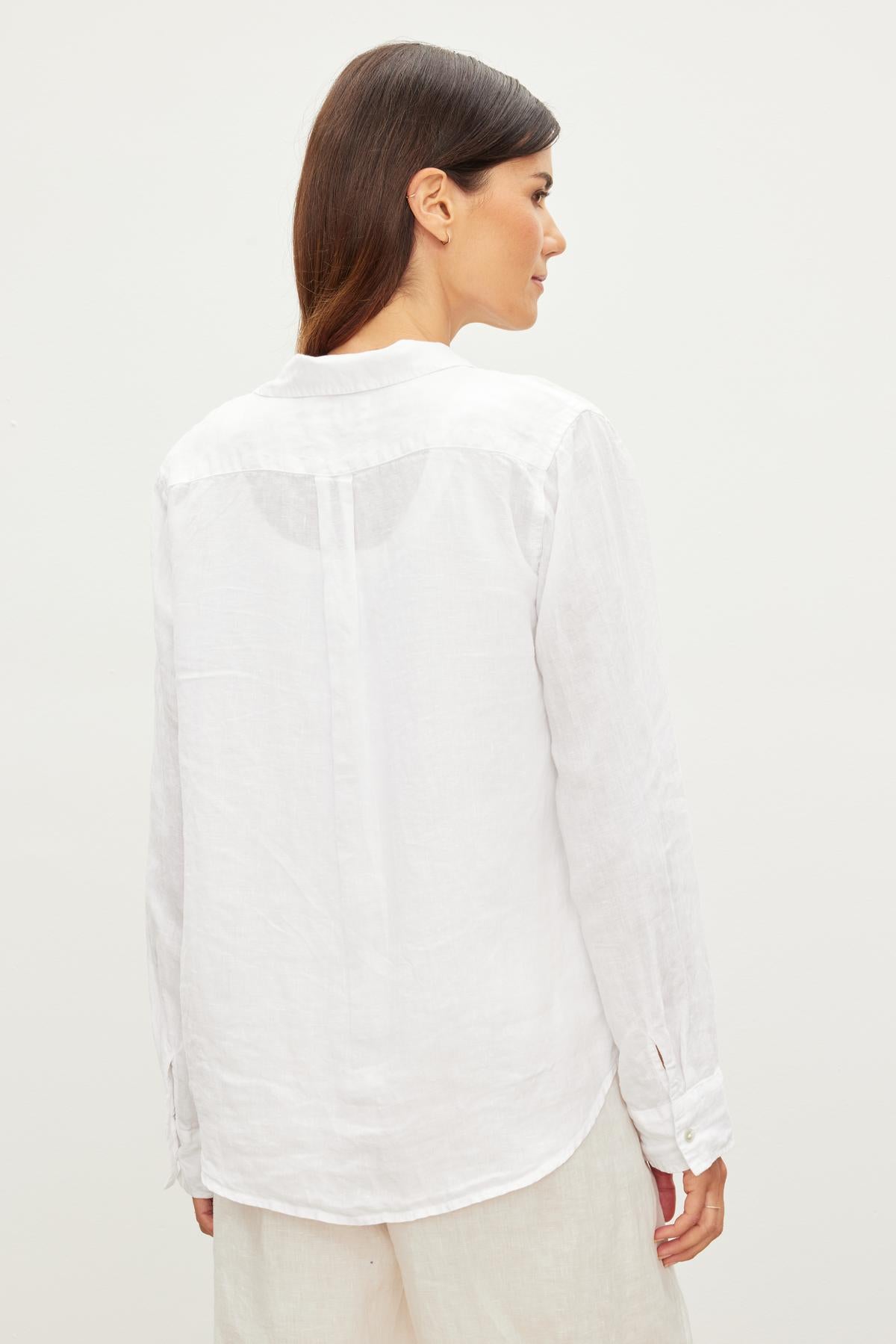 A woman in a Velvet by Graham & Spencer NATALIA LINEN BUTTON-UP SHIRT, perfect for the warmer months.-36010138632385