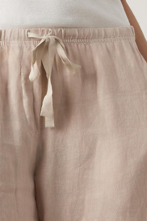 Close-up of a person wearing Velvet by Jenny Graham's PICO LINEN PANT in light pink with an elastic waist, focusing on the waist area.