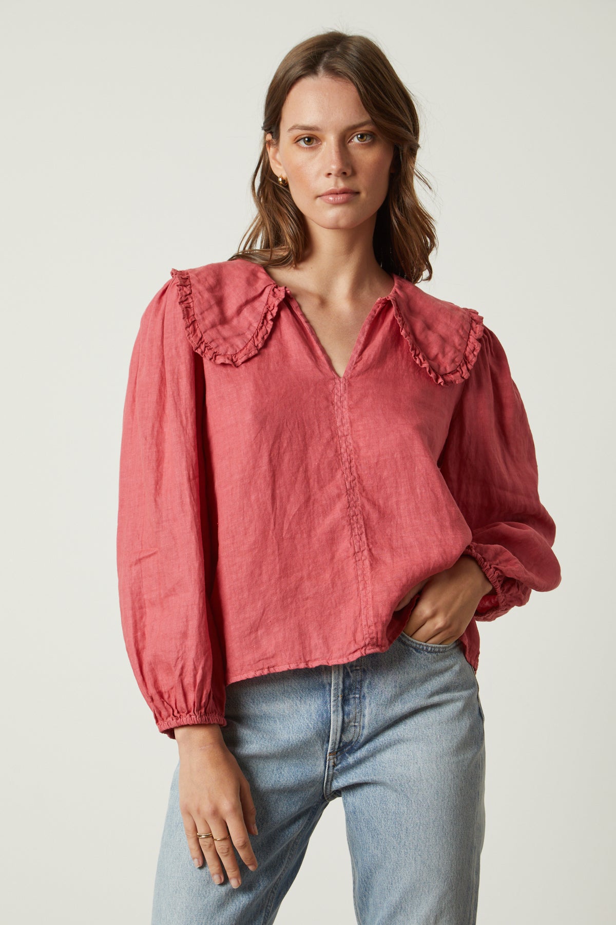   The model is wearing a pink SOFIA LINEN TOP from Velvet by Graham & Spencer with ruffled sleeves. 