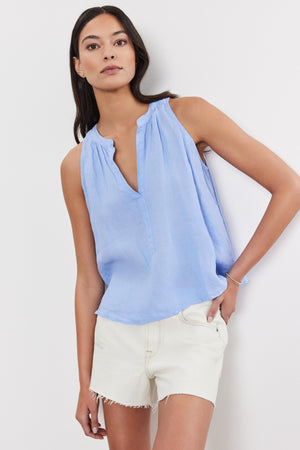 A woman wearing a Velvet by Graham & Spencer Tacy Linen Tank Top and white shorts, standing against a plain background.