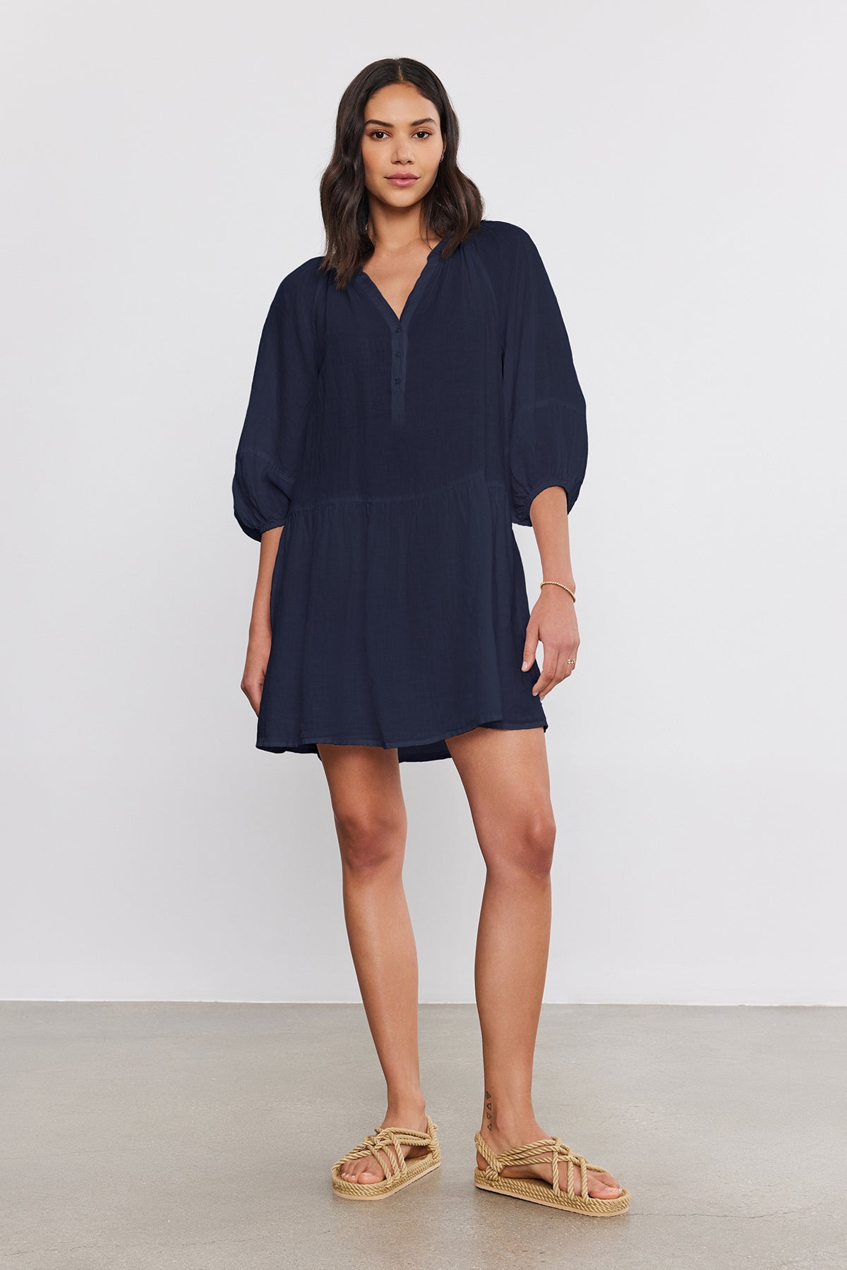   A woman stands in a neutral pose, wearing the Velvet by Graham & Spencer VONNIE LINEN DRESS with puff sleeves and espadrille sandals, against a plain background. 