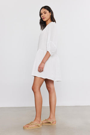 A woman in a VONNIE LINEN DRESS by Velvet by Graham & Spencer and espadrille shoes stands in a profile pose against a grey background.