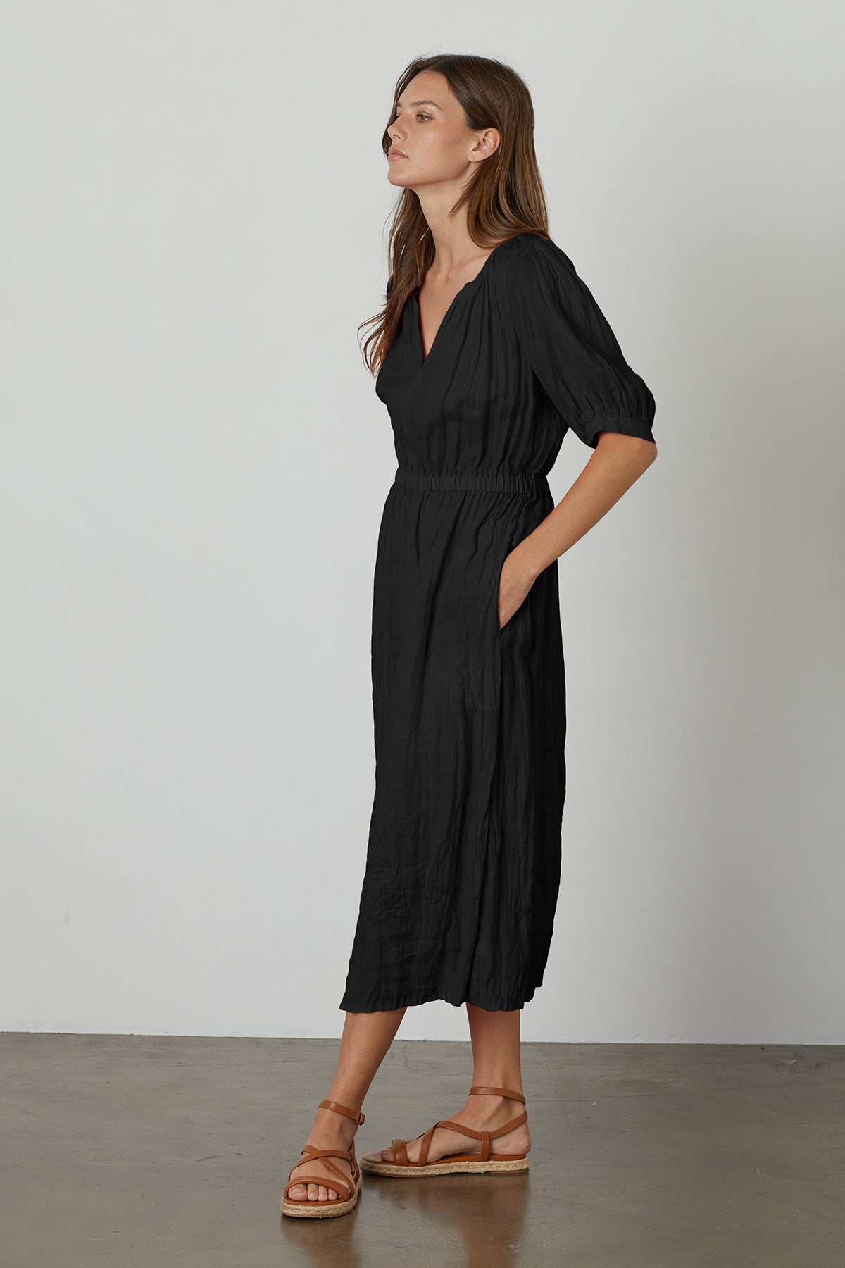   A woman wearing a Velvet by Graham & Spencer WHITNEY LINEN CUT OUT DRESS and sandals. 