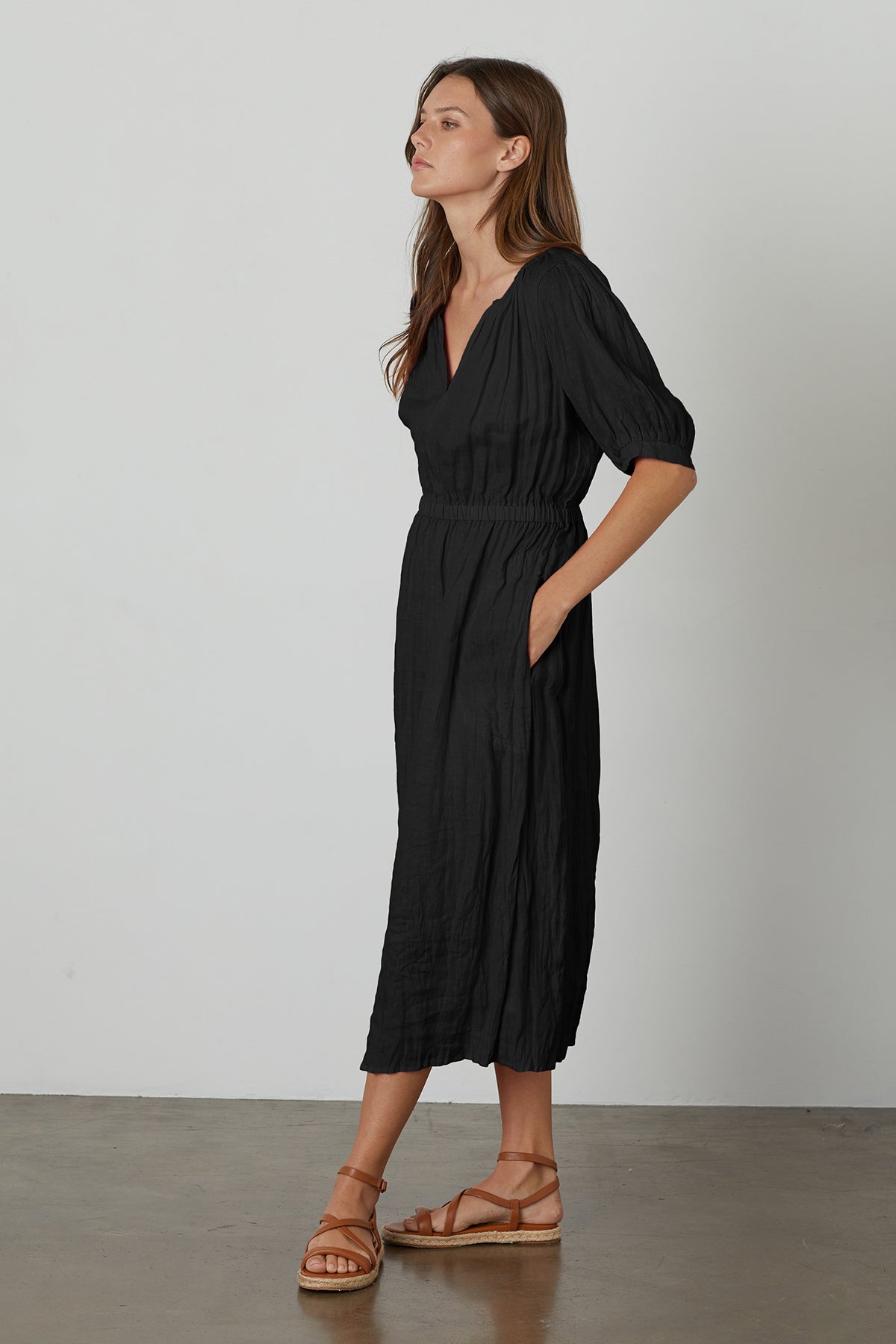 A woman wearing a Velvet by Graham & Spencer WHITNEY LINEN CUT OUT DRESS and sandals.-26671387476161