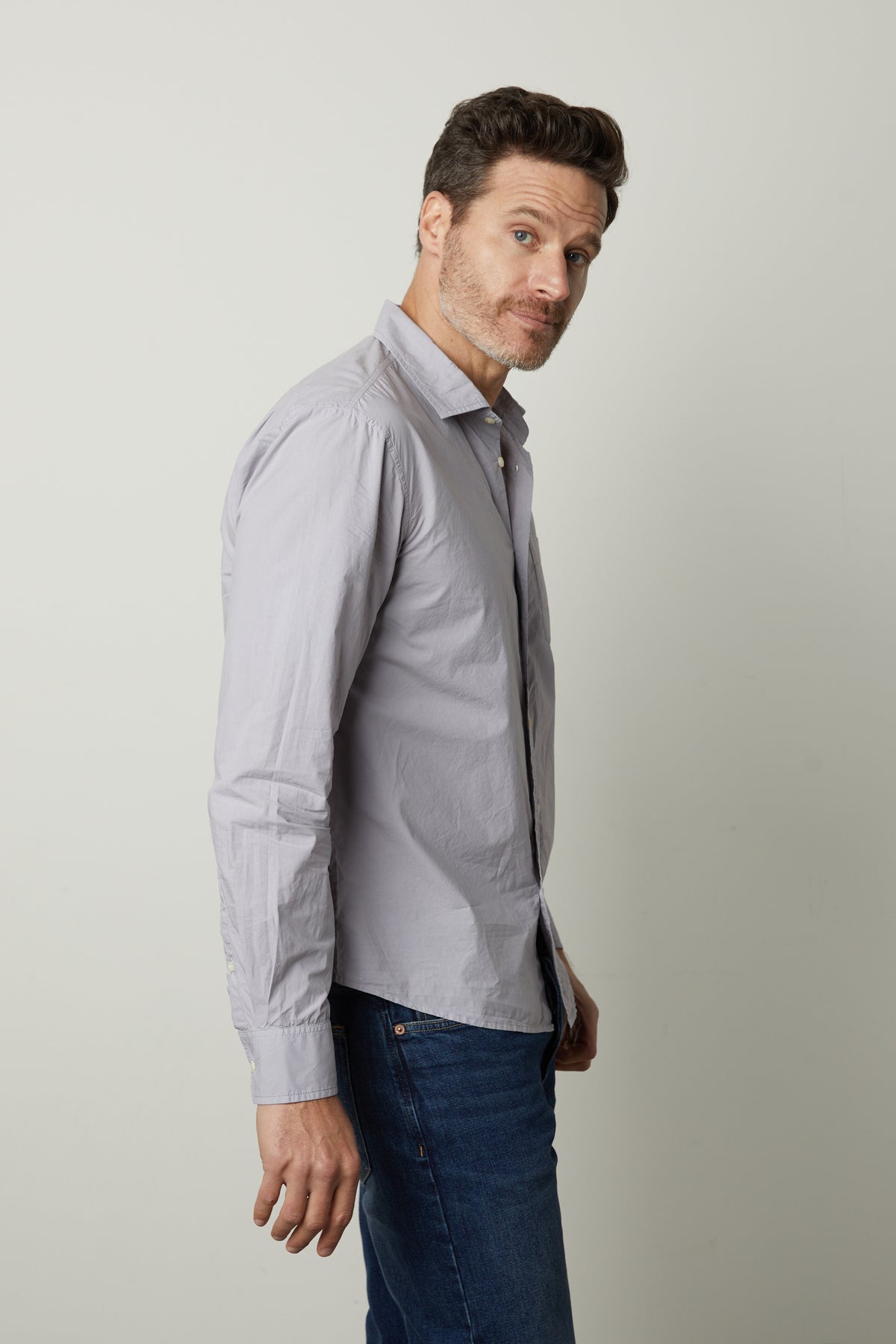A man wearing jeans and a Velvet by Graham & Spencer BROOKS BUTTON-UP SHIRT.-35782370033857