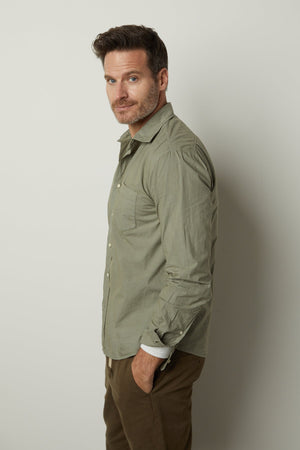 A man wearing a Velvet by Graham & Spencer BROOKS BUTTON-UP SHIRT and khaki pants.