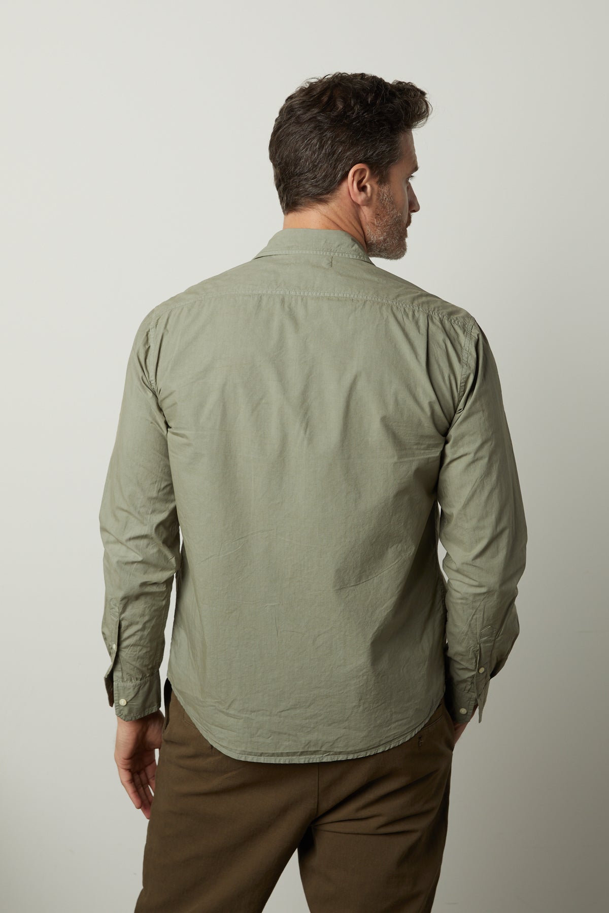   The back view of a man wearing a Velvet by Graham & Spencer BROOKS BUTTON-UP SHIRT and khaki pants. 