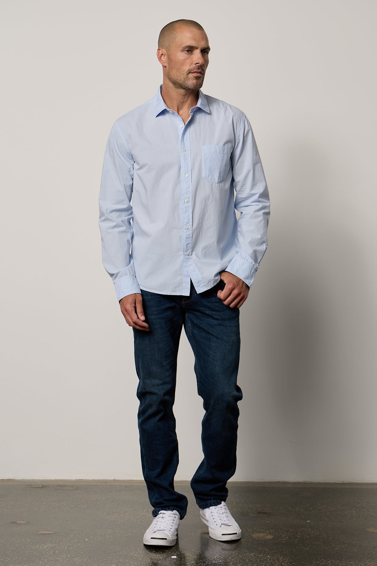   Brooks Button-Up Shirt in mist blue with dark blue denim and white Converse full length front 