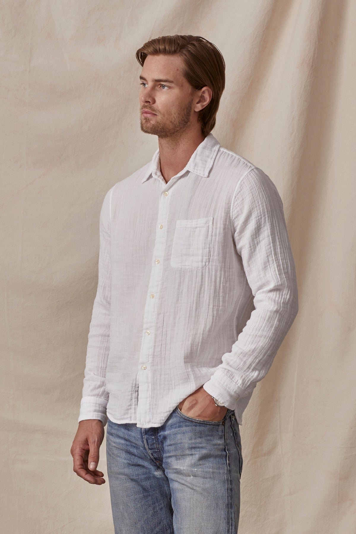 A man wearing casual jeans and an ELTON BUTTON-UP SHIRT by Velvet by Graham & Spencer, made of cotton gauze.-36009391849665