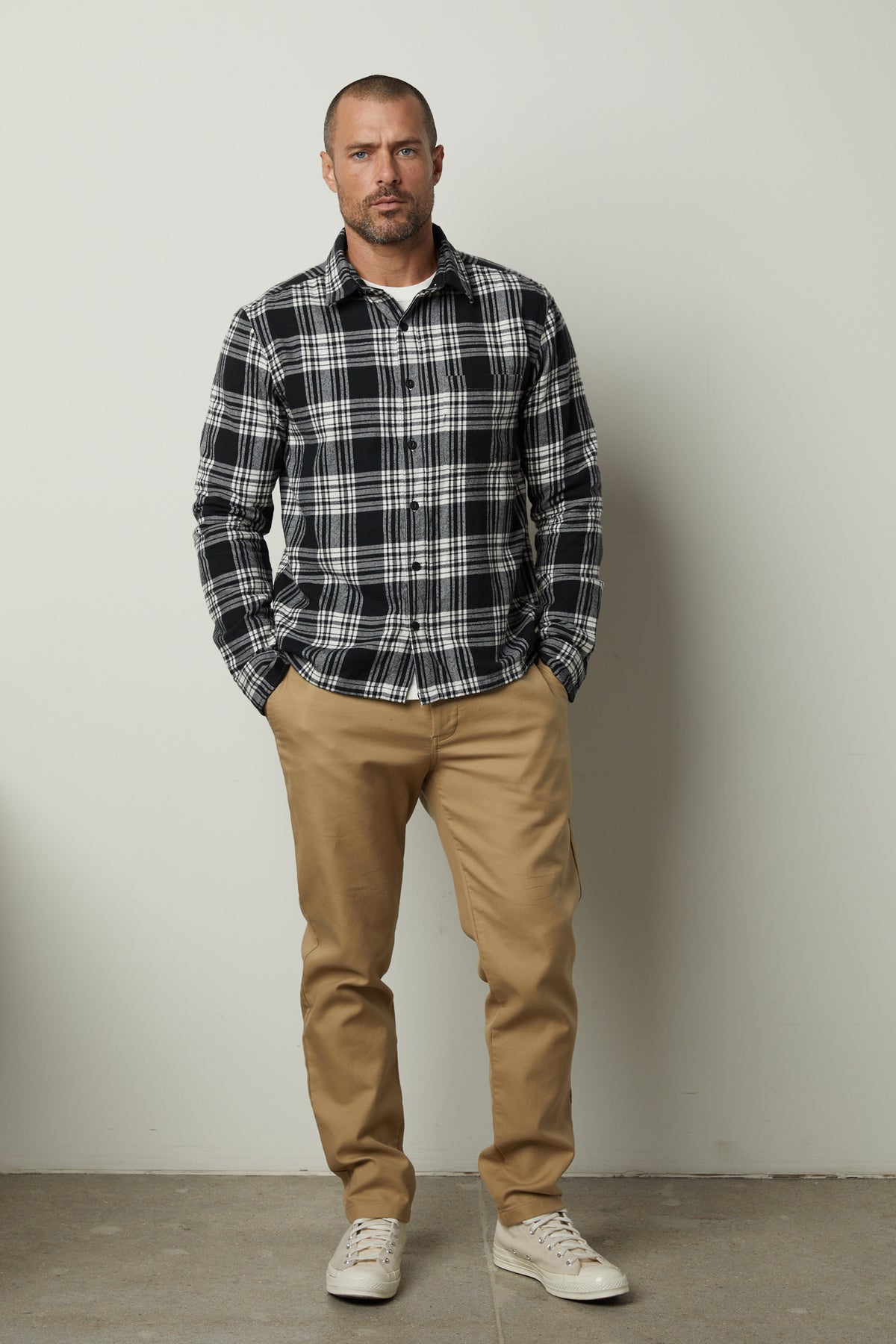   A man wearing a Freddy Plaid Shirt by Velvet by Graham & Spencer. 