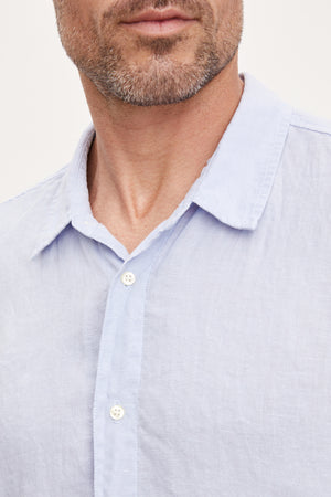 Close-up of a man wearing a Velvet by Graham & Spencer MACKIE LINEN BUTTON-UP SHIRT, focusing on the collar and top buttons.