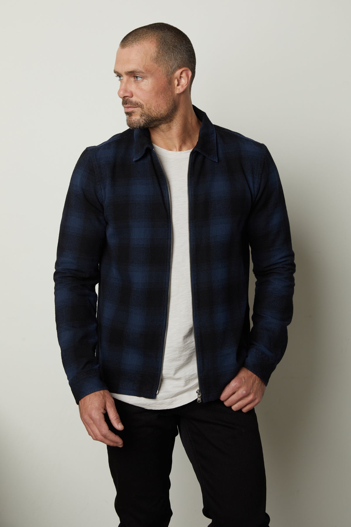 A man wearing a Velvet by Graham & Spencer MARK ZIP-UP PLAID SHIRT jacket.-35231562170561