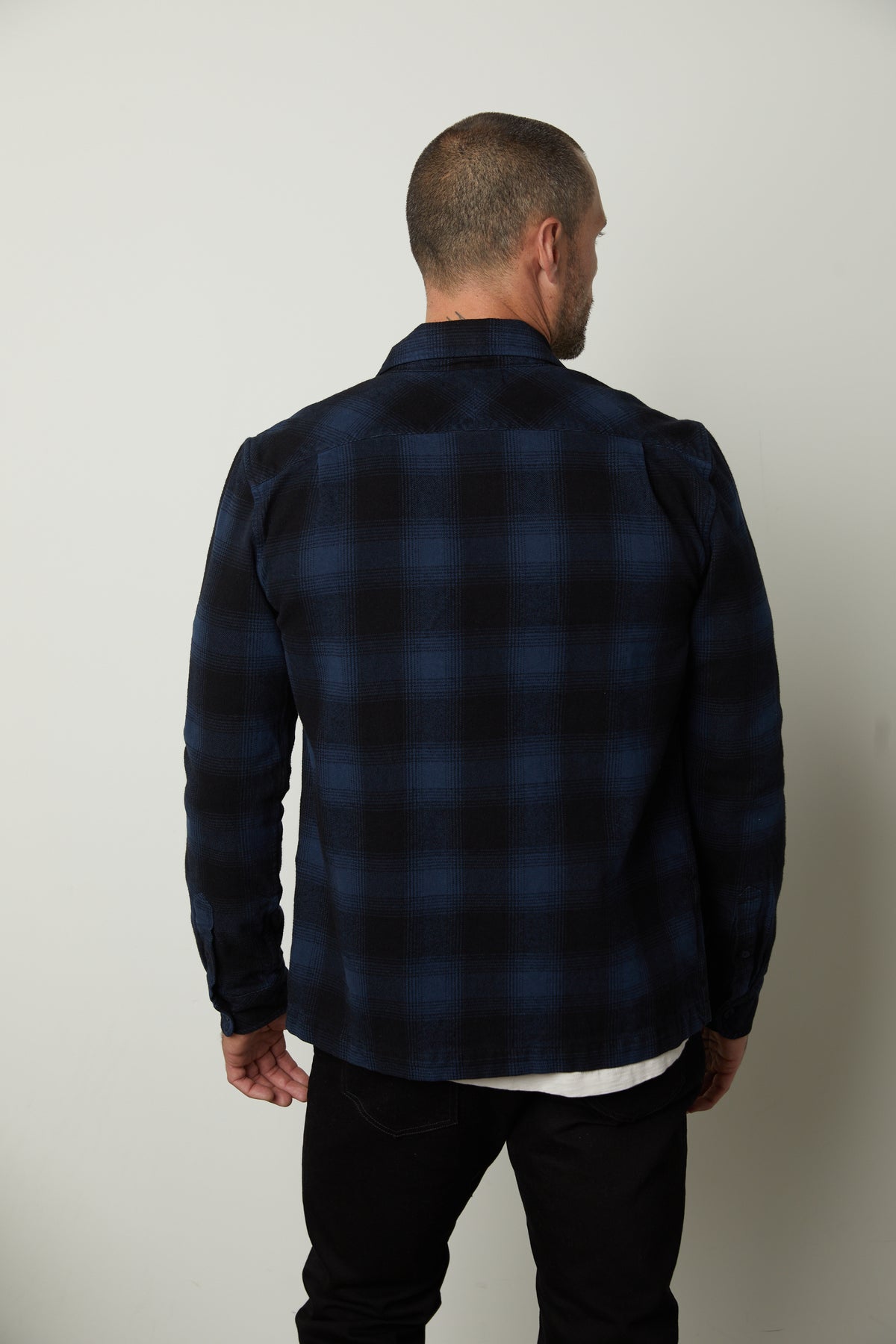   The back of a man wearing a Velvet by Graham & Spencer MARK ZIP-UP PLAID SHIRT made of cotton woven fabric. 