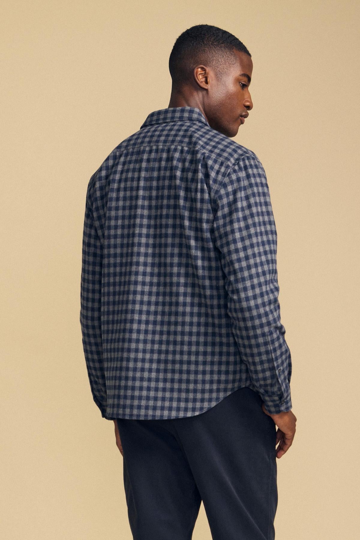 A person seen from the back wearing a long-sleeved navy and grey plaid DANNY PLAID BUTTON-UP SHIRT.-46287908438209