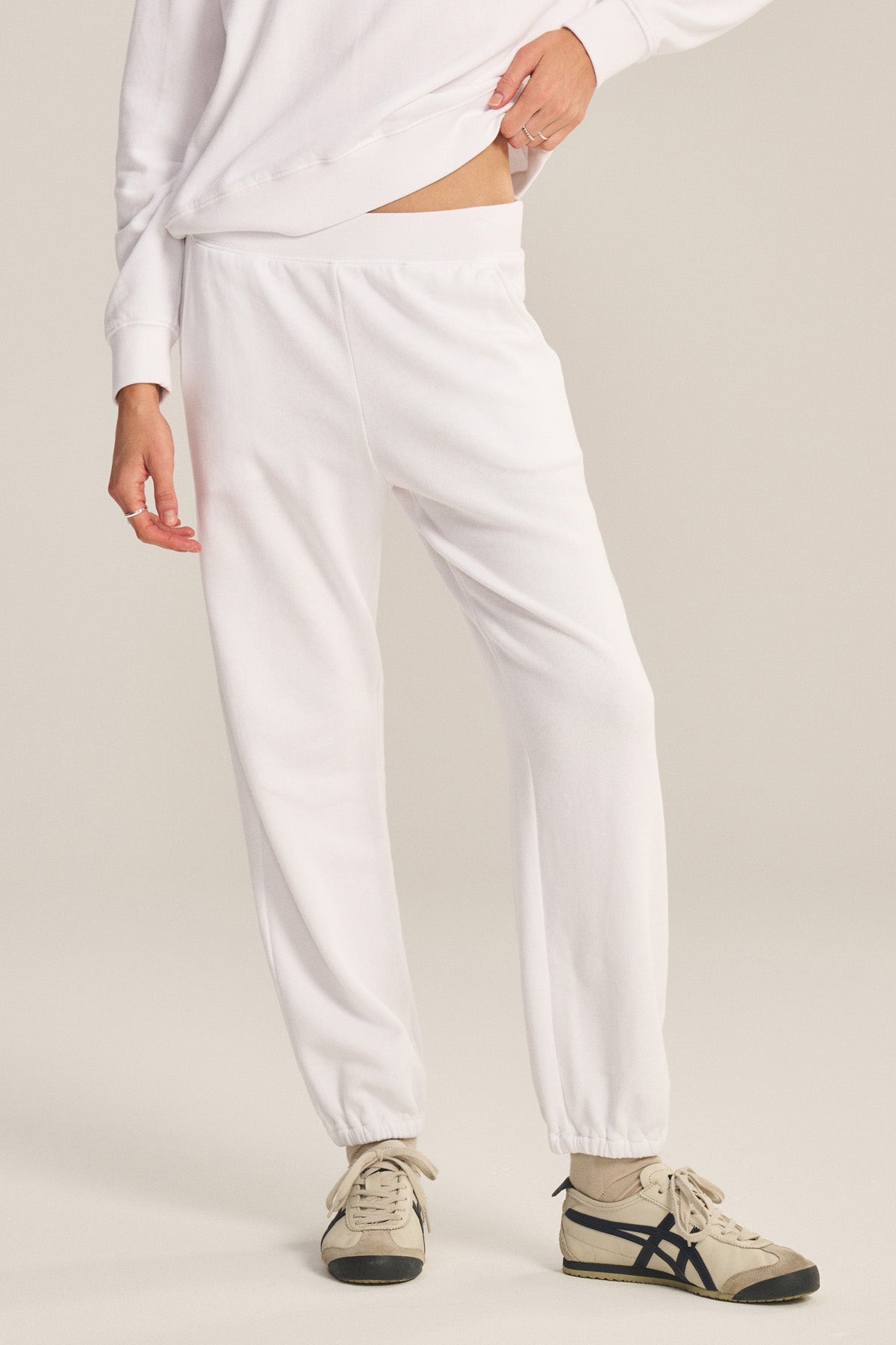 A person wears relaxed fit white ZARA SWEATPANT by Velvet by Graham & Spencer, a white sweatshirt, and beige sneakers with black accents. Made from soft cotton fleece for all-day comfort and style, against a plain background.-40294540017857