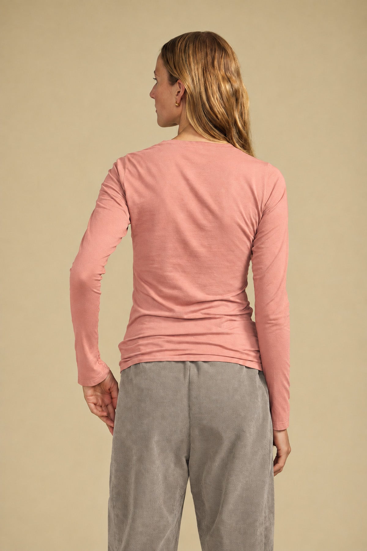 Back view of a person wearing a dusty pink ZOFINA TEE by Velvet by Graham & Spencer with a classic crew neckline and grey pants.