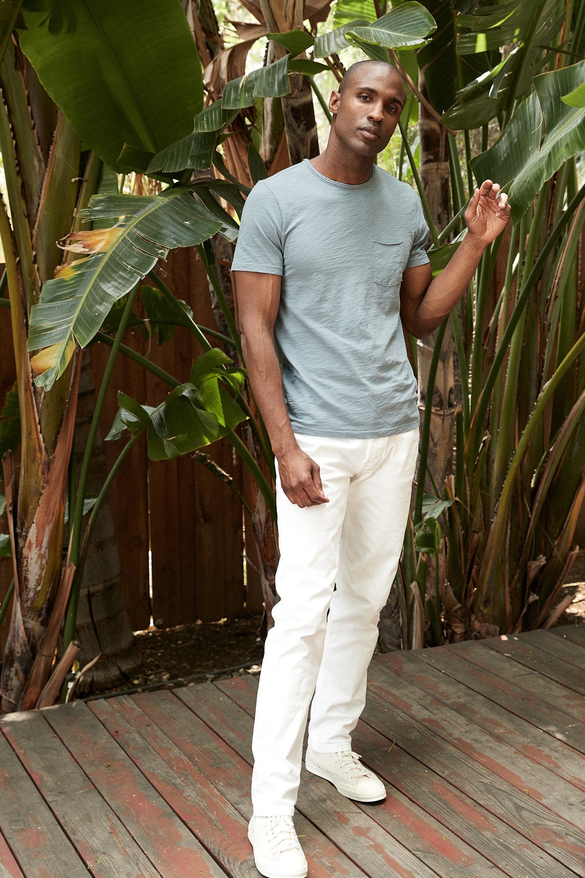   Chad Raw Edge Cotton Slub Pocket Tee in riptide with white denim model standing outside near plants with white denim 