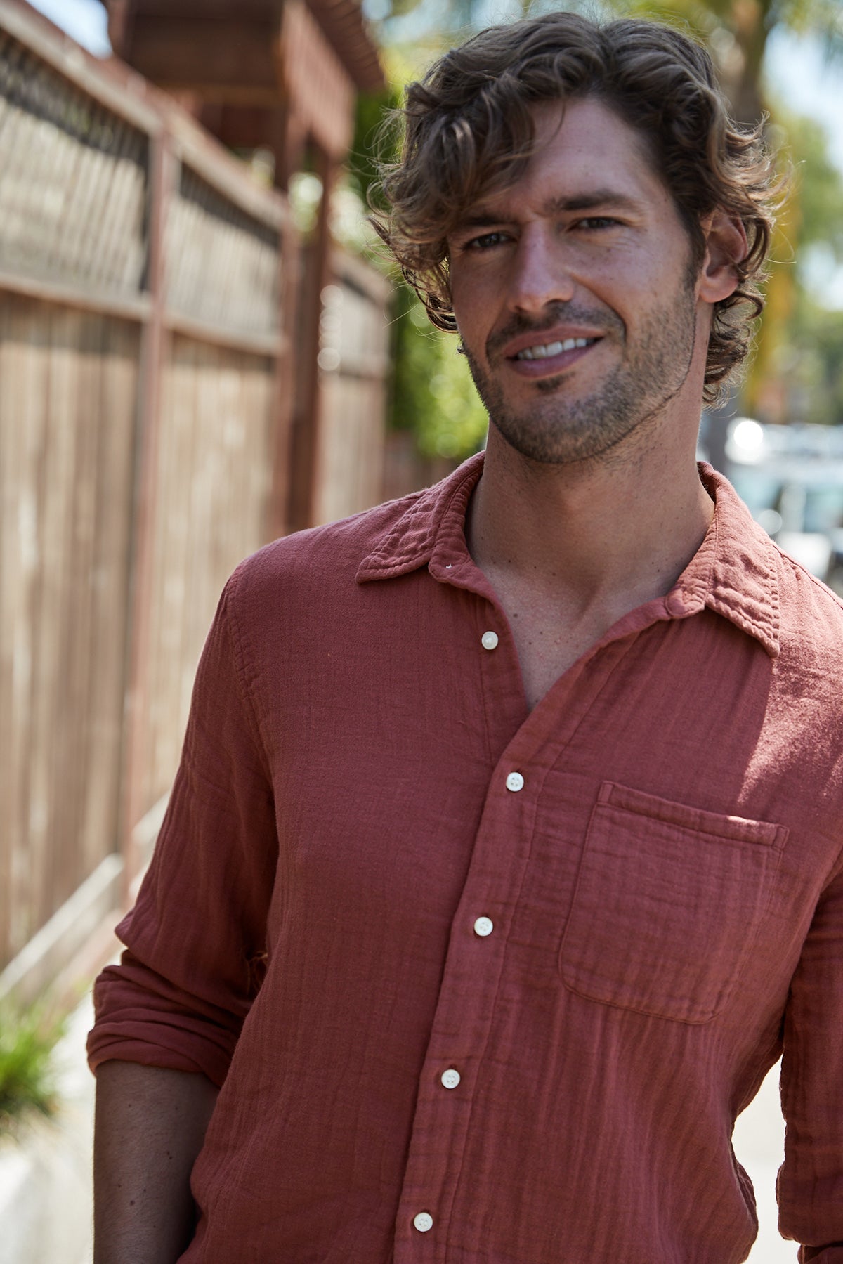 A man in a Velvet by Graham & Spencer ELTON BUTTON-UP SHIRT standing on a sidewalk.-25793275789505
