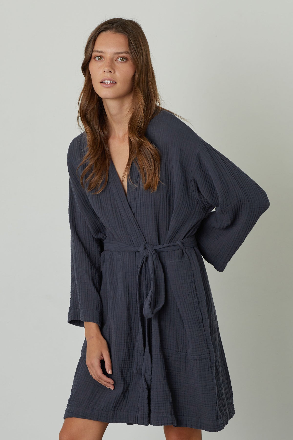   A woman wearing a soft-textured MINI COTTON GAUZE ROBE from Jenny Graham Home with a belt. 