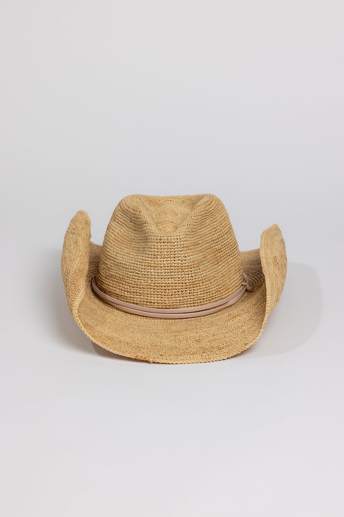   A RAFFIA CROCHET COWBOY HAT with western charm on a white background, by Velvet by Graham & Spencer. 