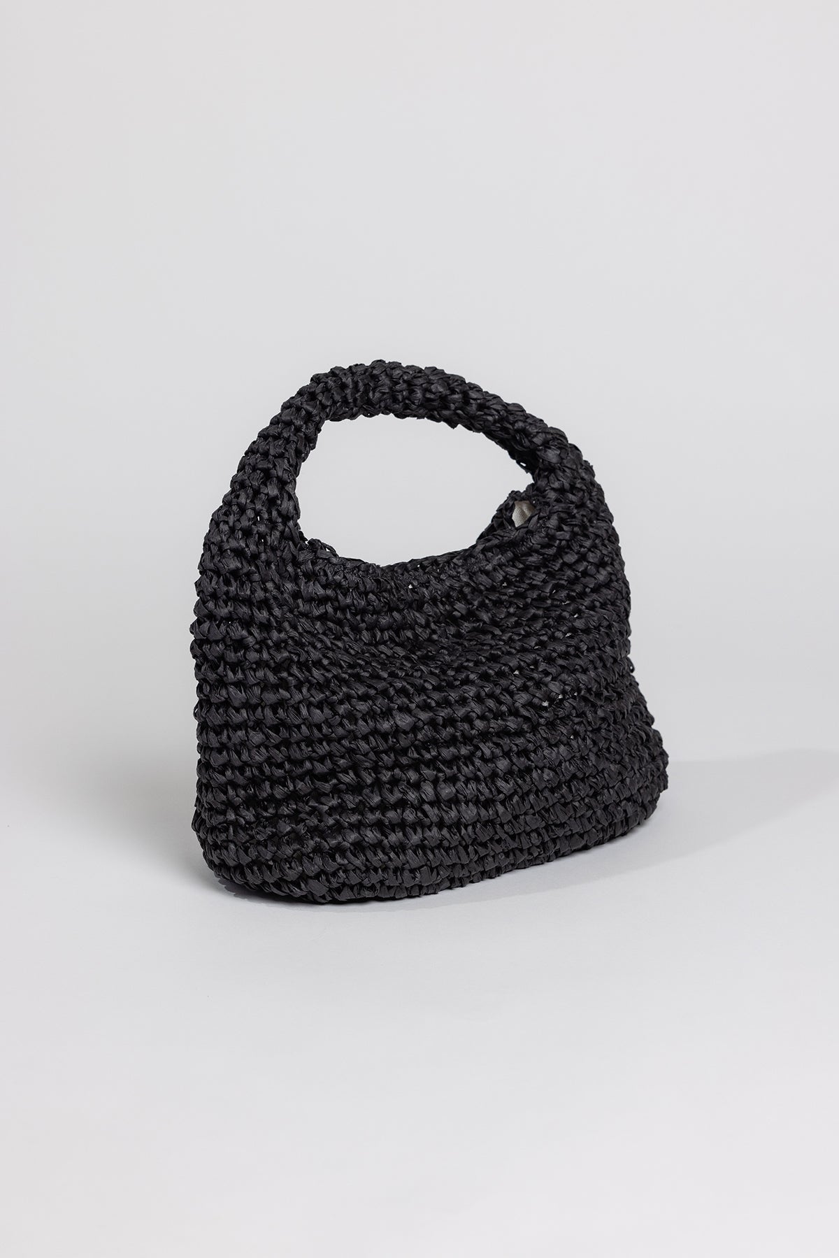 Sentence with replacement: Black crocheted Velvet by Graham & Spencer SLOUCH BAG with a wrist loop, shown against a plain white background.-26166343958721