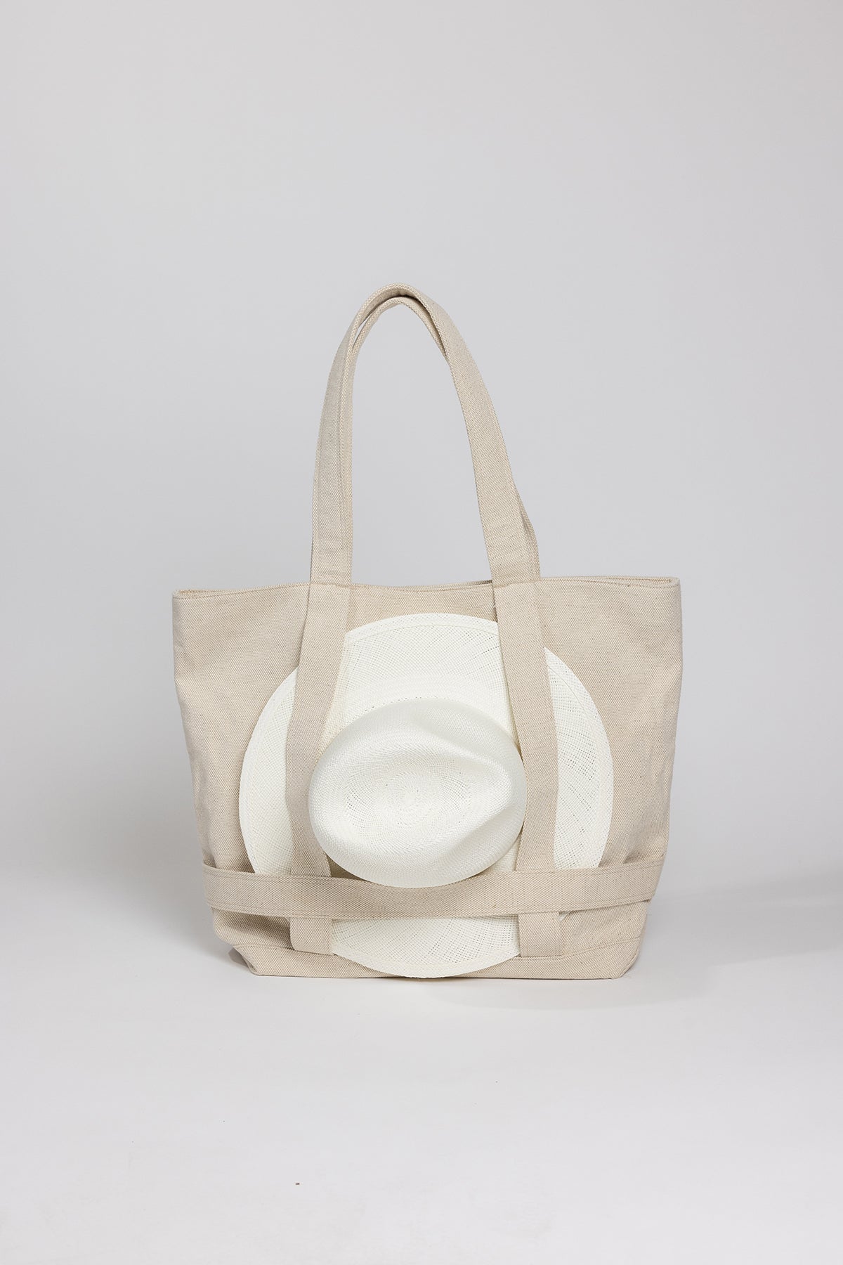 a beige ORIGINAL CANVAS TRAVELER BAG with a white hat on it. (Brand: Velvet by Graham & Spencer)-26051038478529