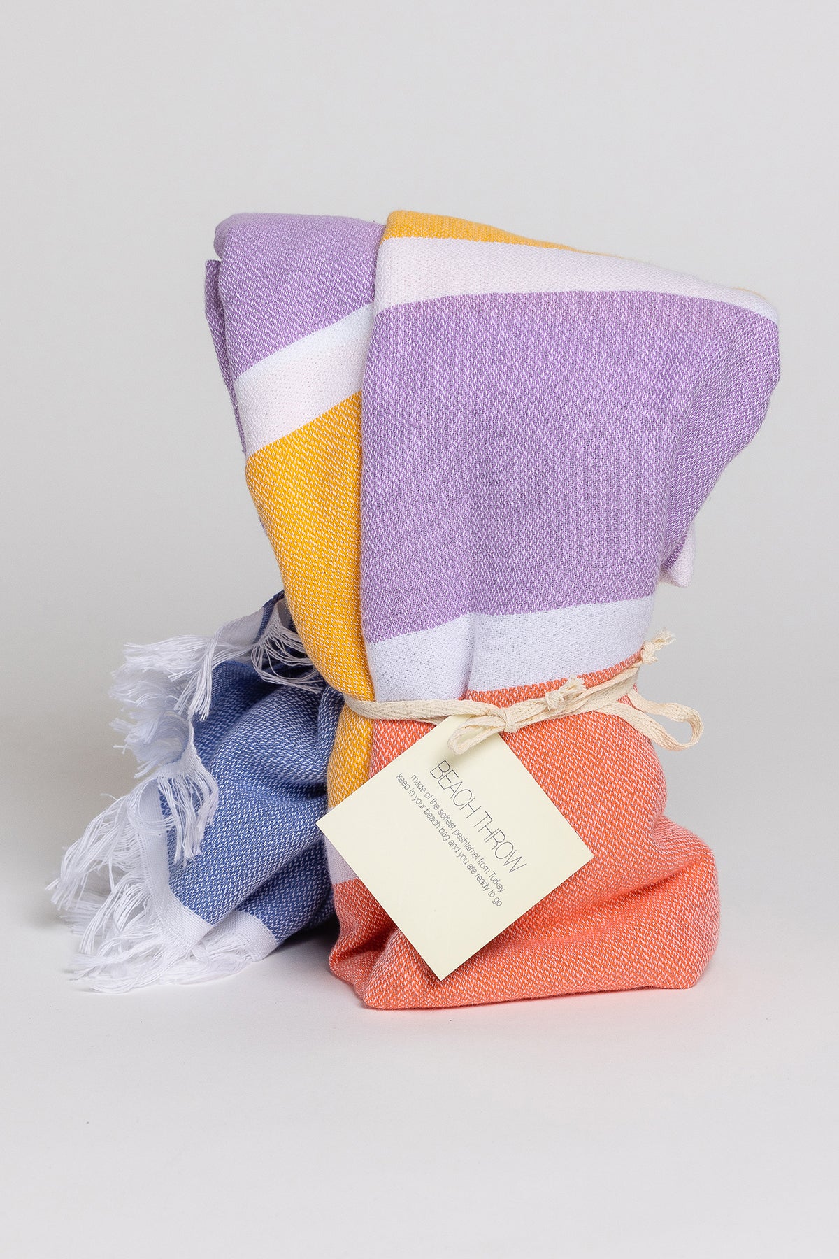 a Velvet by Graham & Spencer BEACH THROW towel with a tag on it.-26205585375425