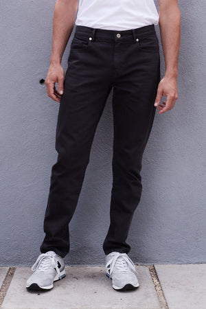 a man wearing JOSEPH COTTON CANVAS PANT jeans and a white t-shirt by Velvet by Graham & Spencer.