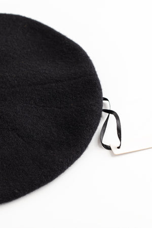A Gigi beret made from a luxurious merino wool blend, with a stylish tag bearing the name 