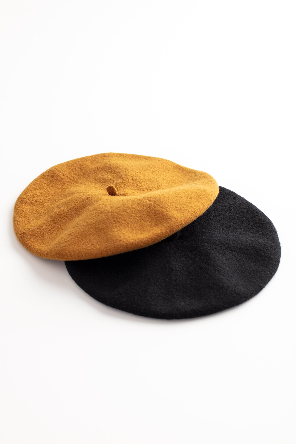 Two Gigi Berets by Hansel from Basel, made of a Merino wool blend, on a white surface.-615355842641
