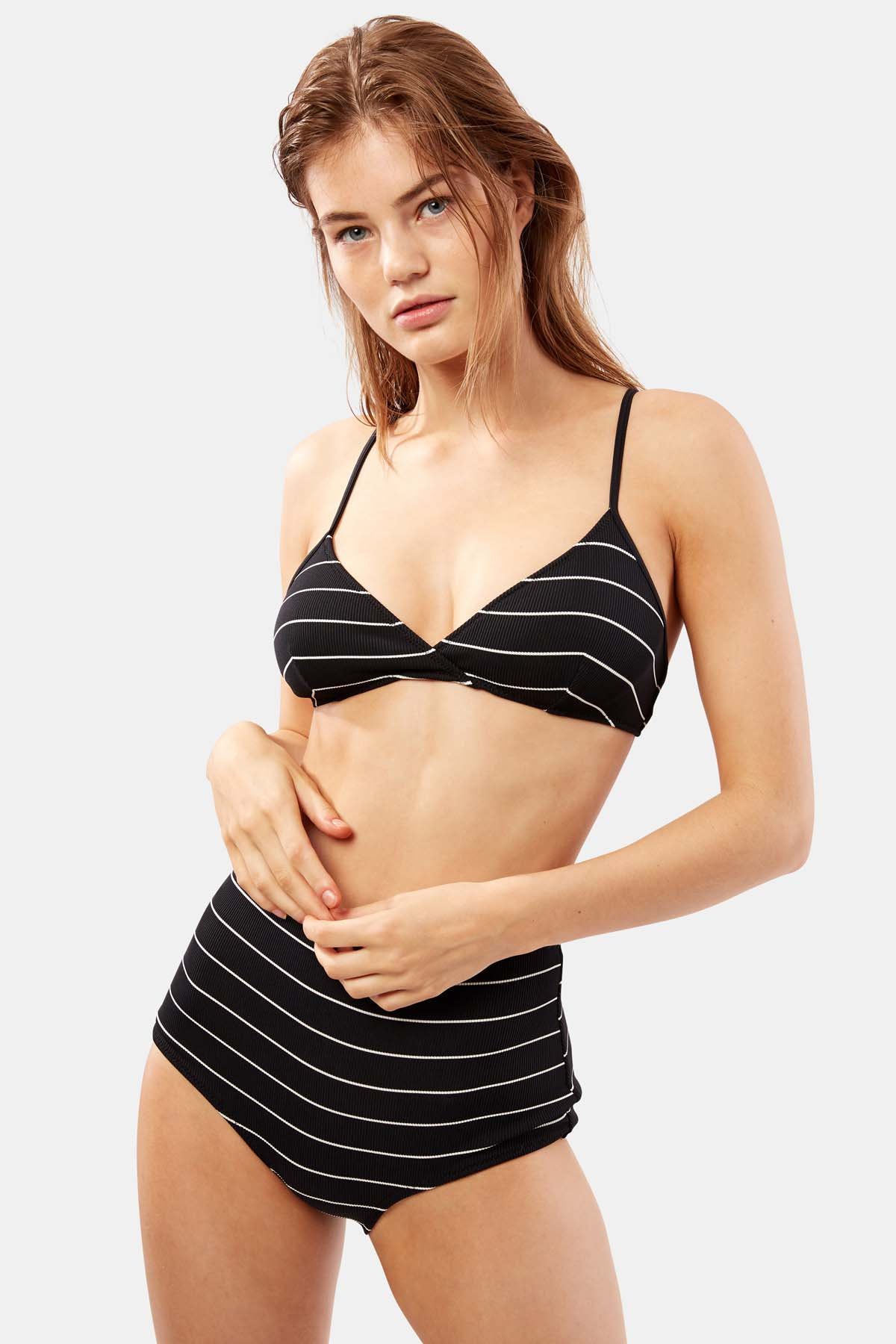   A woman wearing a BRIGITTE PINSTRIPE RIBBED SWIM BOTTOM BY SOLID AND STRIPED swimwear top. 