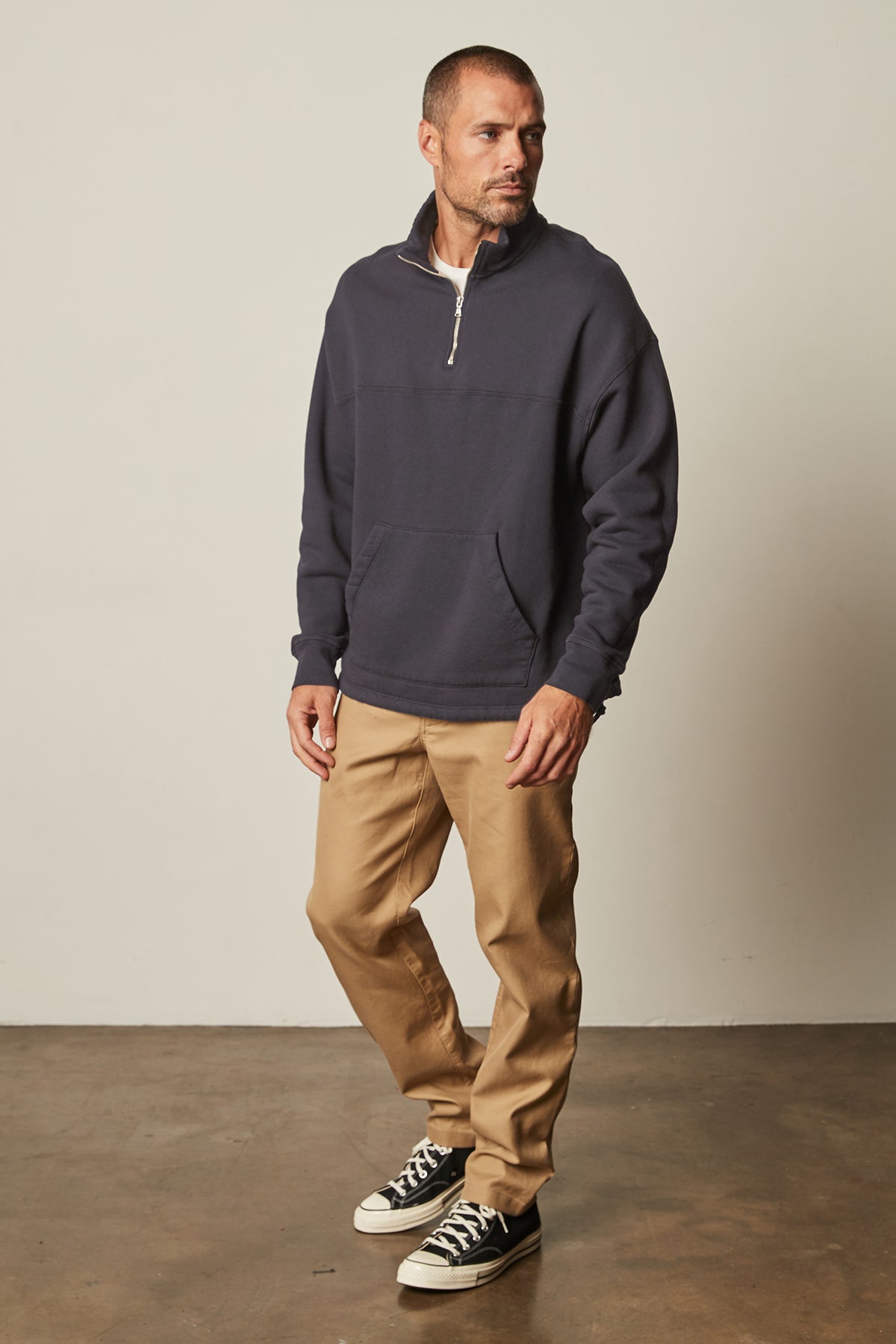   Baldwin Quarter-Zip Sweatshirt in blue ink front with khaki Aiden pants and Converse full length front 