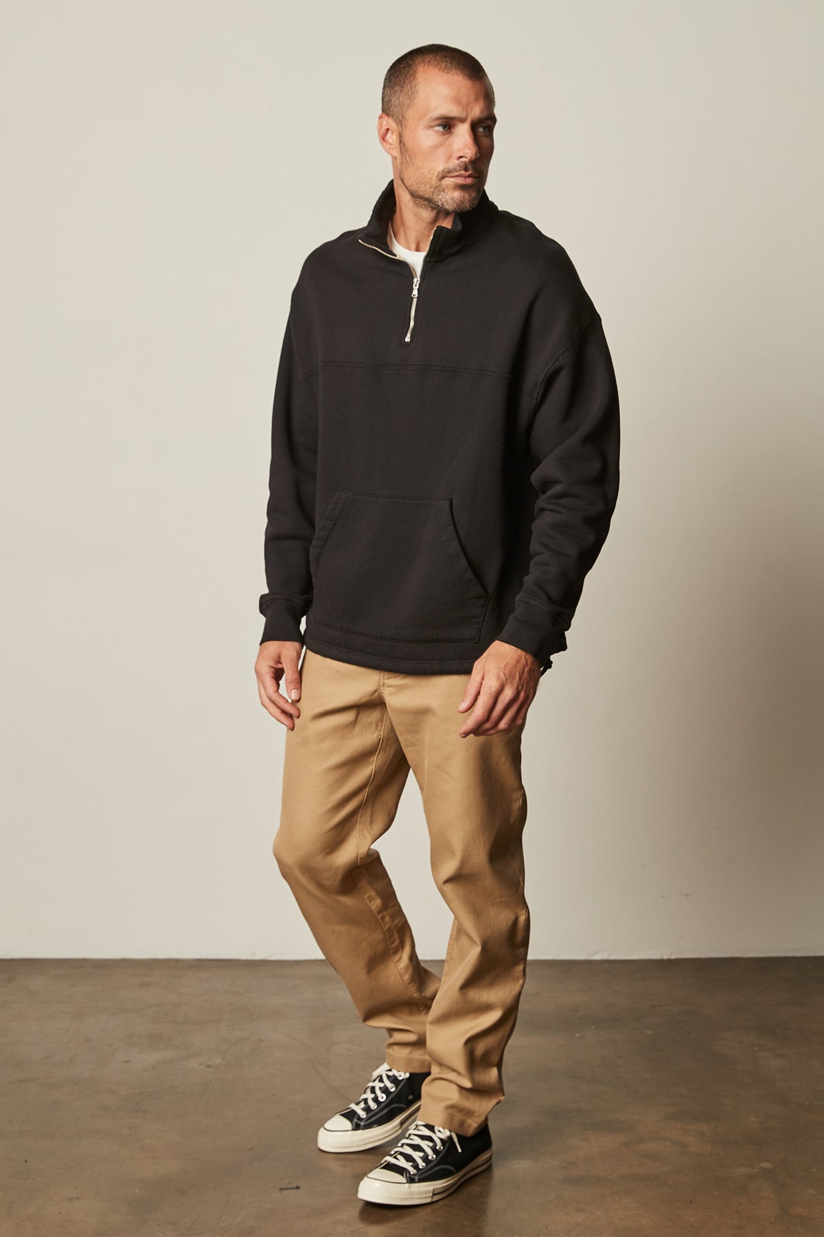   Baldwin Quarter-Zip Sweatshirt in black with khaki Aiden pants and Converse full length front 