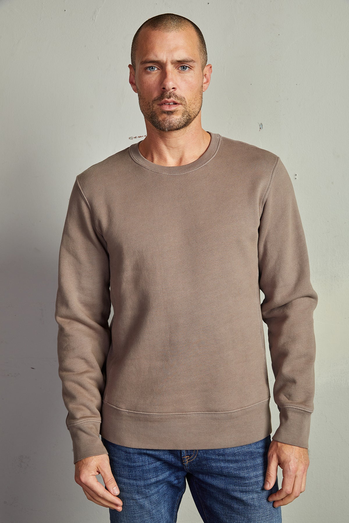 A man wearing a Velvet by Graham & Spencer KING CREW NECK SWEATSHIRT and jeans with clean lines.-14889960538305