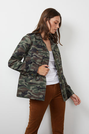A woman wearing a Ruby Light-Weight Army Jacket by Velvet by Graham & Spencer and brown pants.