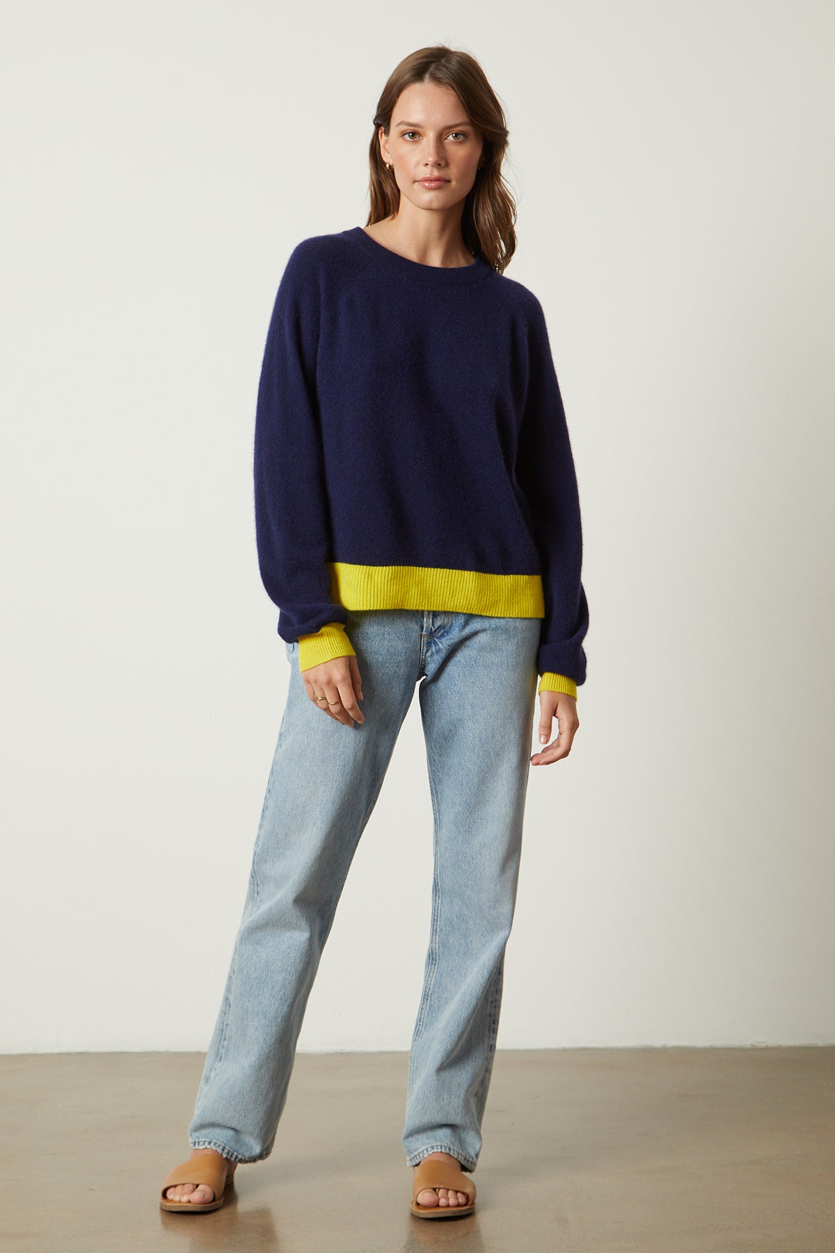   Claire Sweater in navy with yellow contrast at the cuffs and hemline with blue denim full length front 
