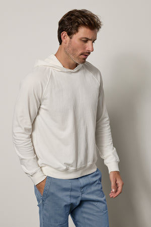 A man in a casual slouch wearing a Velvet by Graham & Spencer GREG HOODIE.