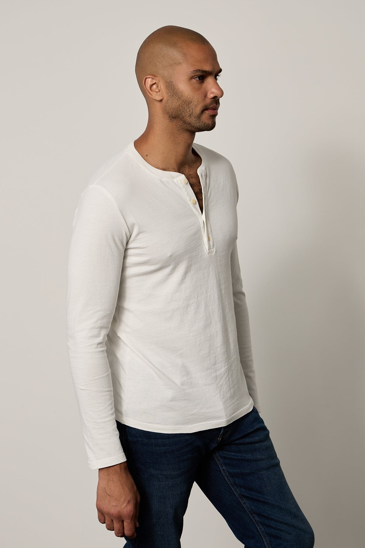   a man wearing jeans and a white Velvet by Graham & Spencer BRAD HENLEY t - shirt. 