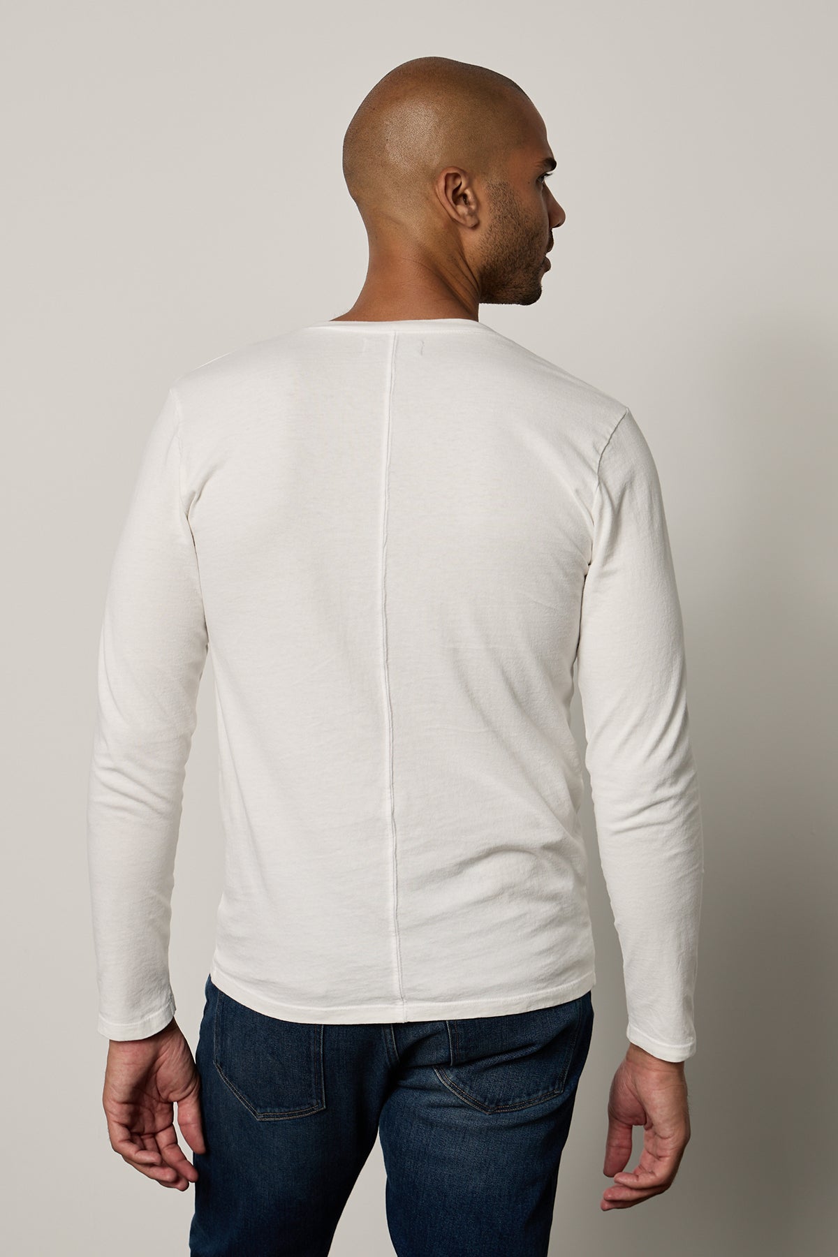   the back of a man wearing BRAD HENLEY jeans and a white long sleeve tee by Velvet by Graham & Spencer. 