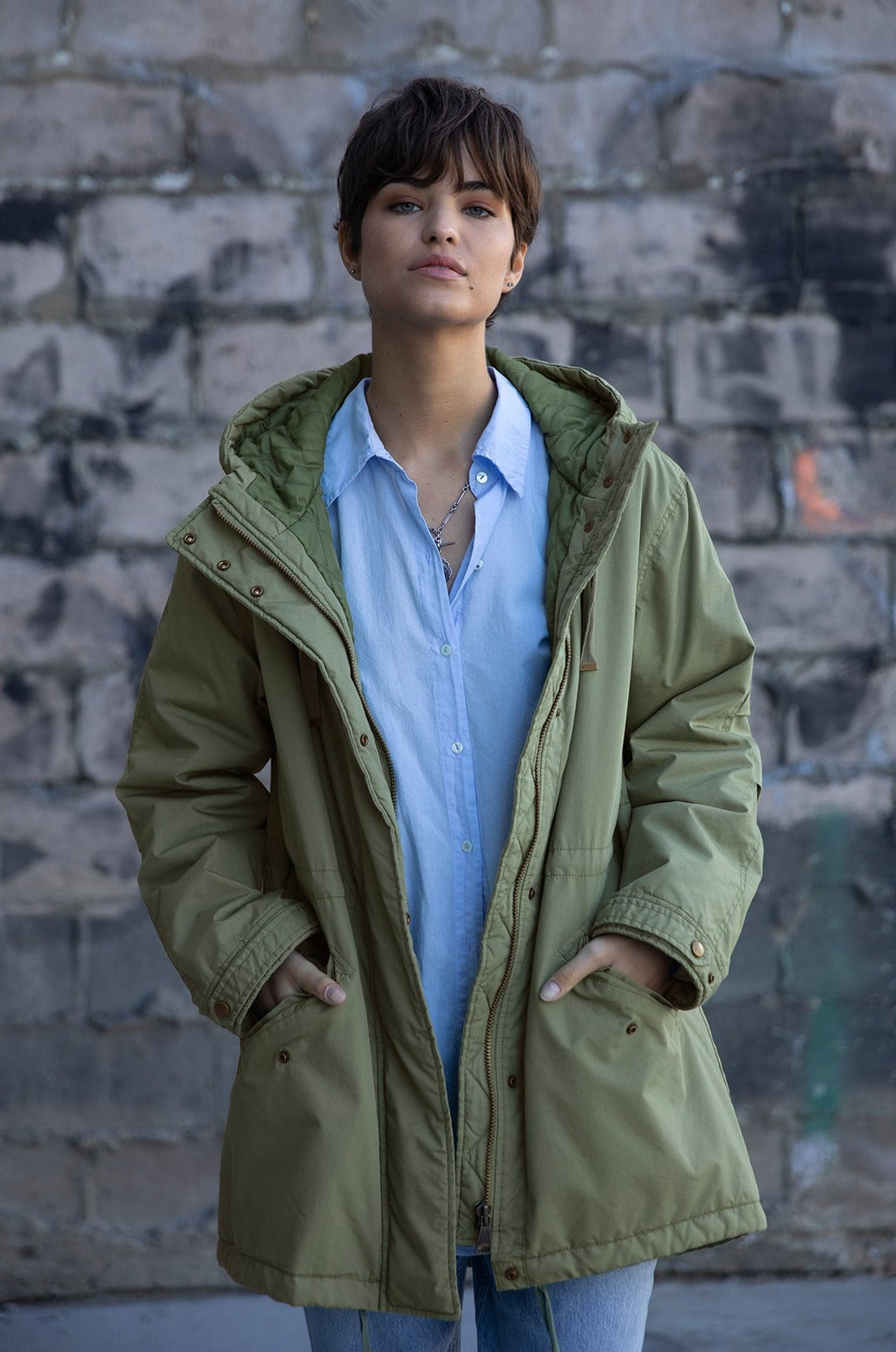   Cheviot Jacket in evergreen layered over Redondo shirt in mist blue front model hands in pockets. 