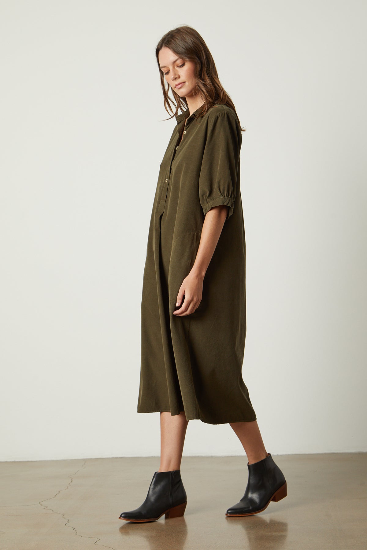 A soft, pinwhale corduroy JOSIE CORDUROY DRESS by Velvet by Graham & Spencer in green, paired with black boots and featuring a detachable belt.-25085241360577