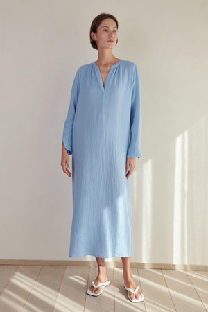 A woman wearing the Velvet by Jenny Graham DOHENY DRESS standing in front of a white wall.