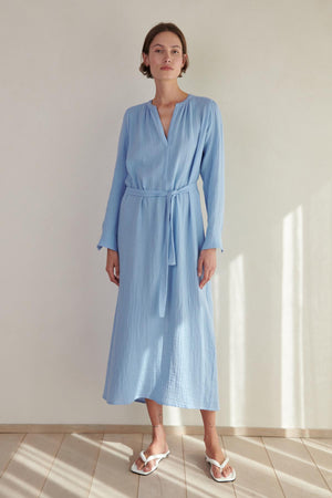 A woman wearing a blue DOHENY DRESS by Velvet by Jenny Graham and sandals.