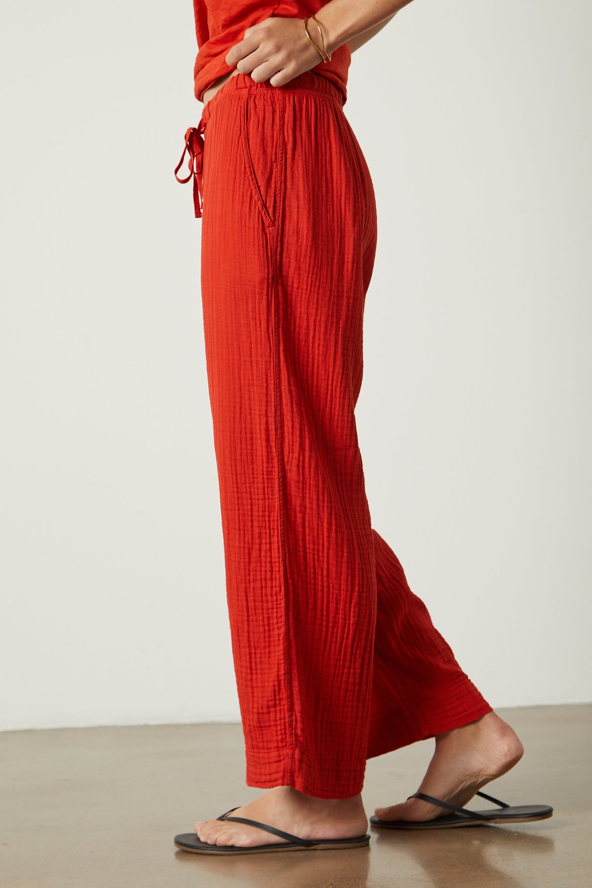   A woman wearing FRANNY COTTON GAUZE PANT by Velvet by Graham & Spencer wide leg pants and sandals. 