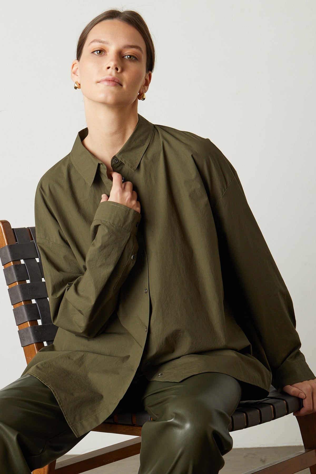 Model sitting in chair wearing Dakota Button-Up Shirt in olivine with Rihanna Vegan Leather Pants-25669056004289