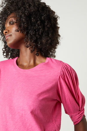 A black woman wearing an AMELIA PUFF SLEEVE TEE by Velvet by Graham & Spencer.