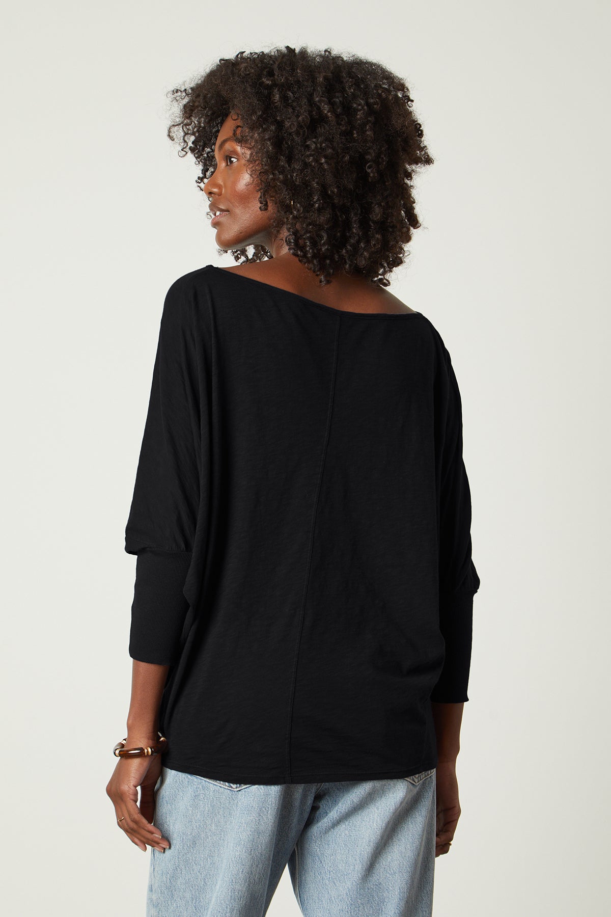   Back view of a woman wearing the Velvet by Graham & Spencer JOSS DOLMAN SLEEVE TEE and jeans. 